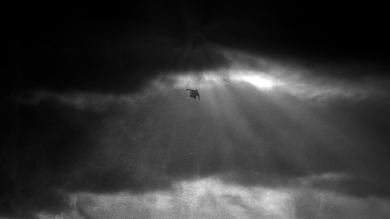 Ein Mann fällt aus einer dunklen Wolke herab am Set des Musikvideos Conchita Heroes